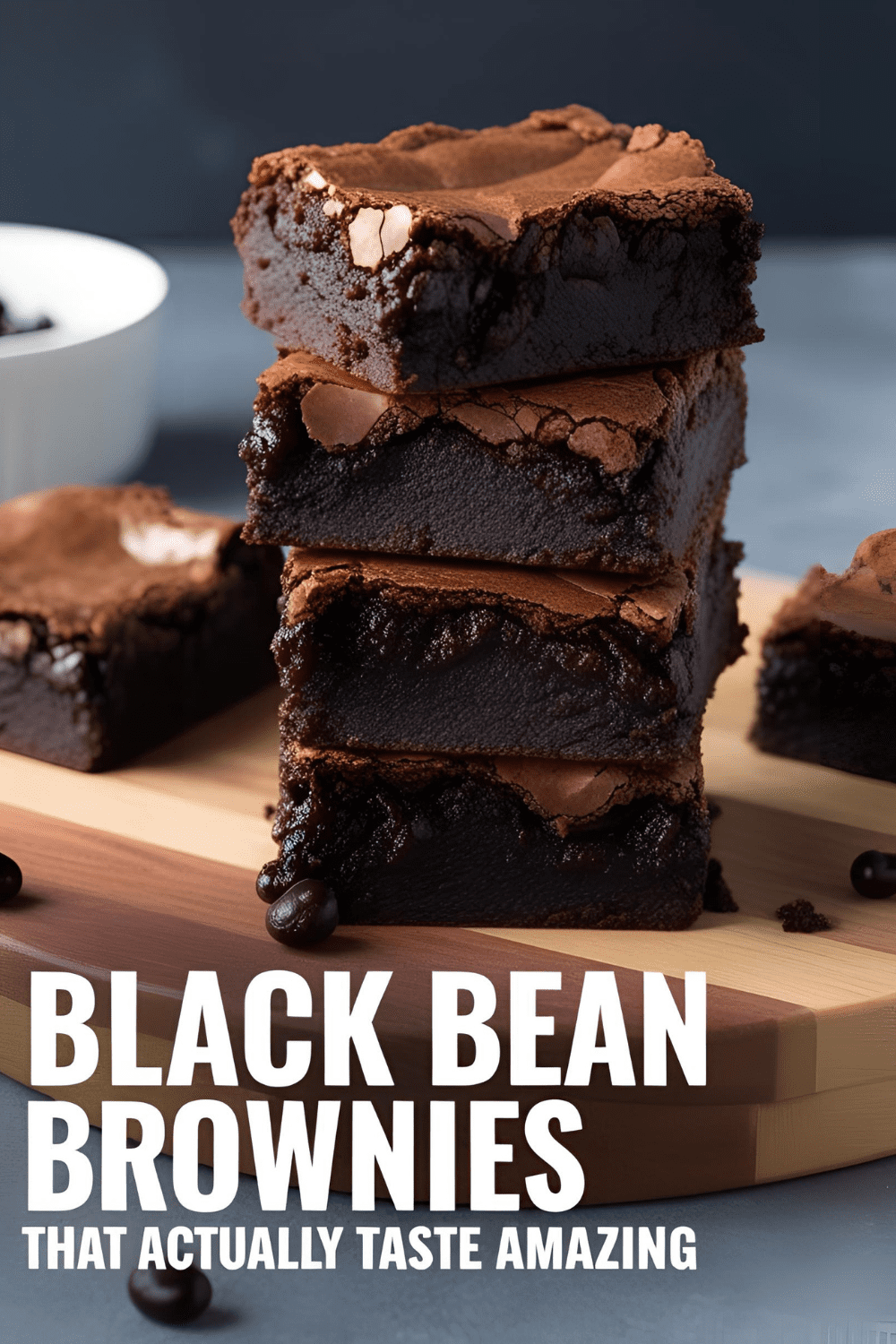 Fudgy black bean brownies stacked on a wooden board with melted chocolate chips