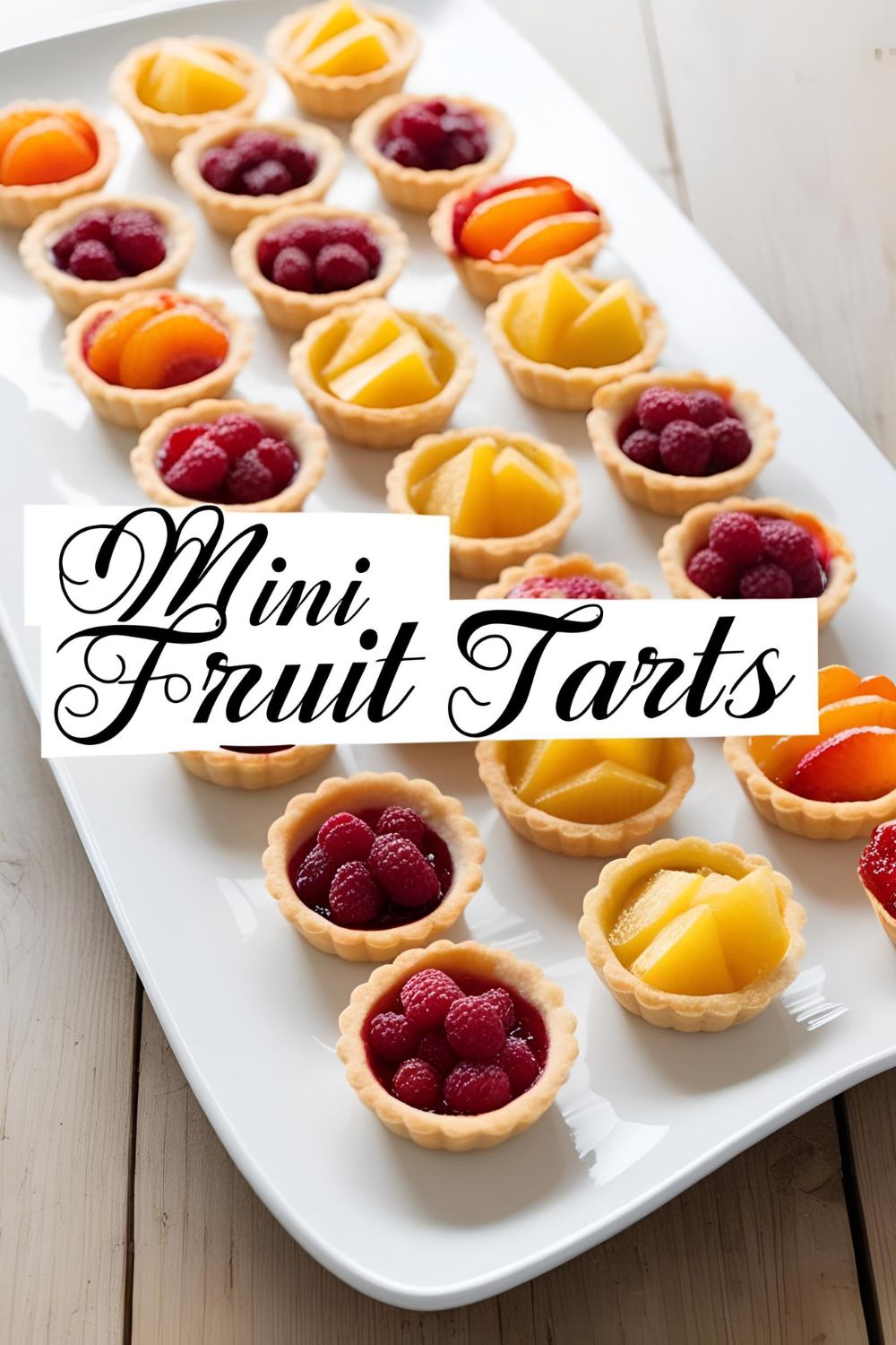 "Assorted mini fruit tarts with fresh berries and kiwi on a white serving platter."