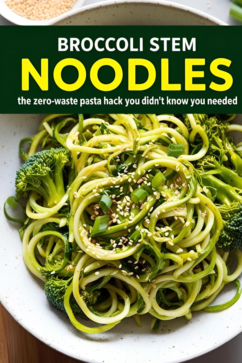 A bowl of broccoli stem noodles garnished with sesame seeds and green onions.