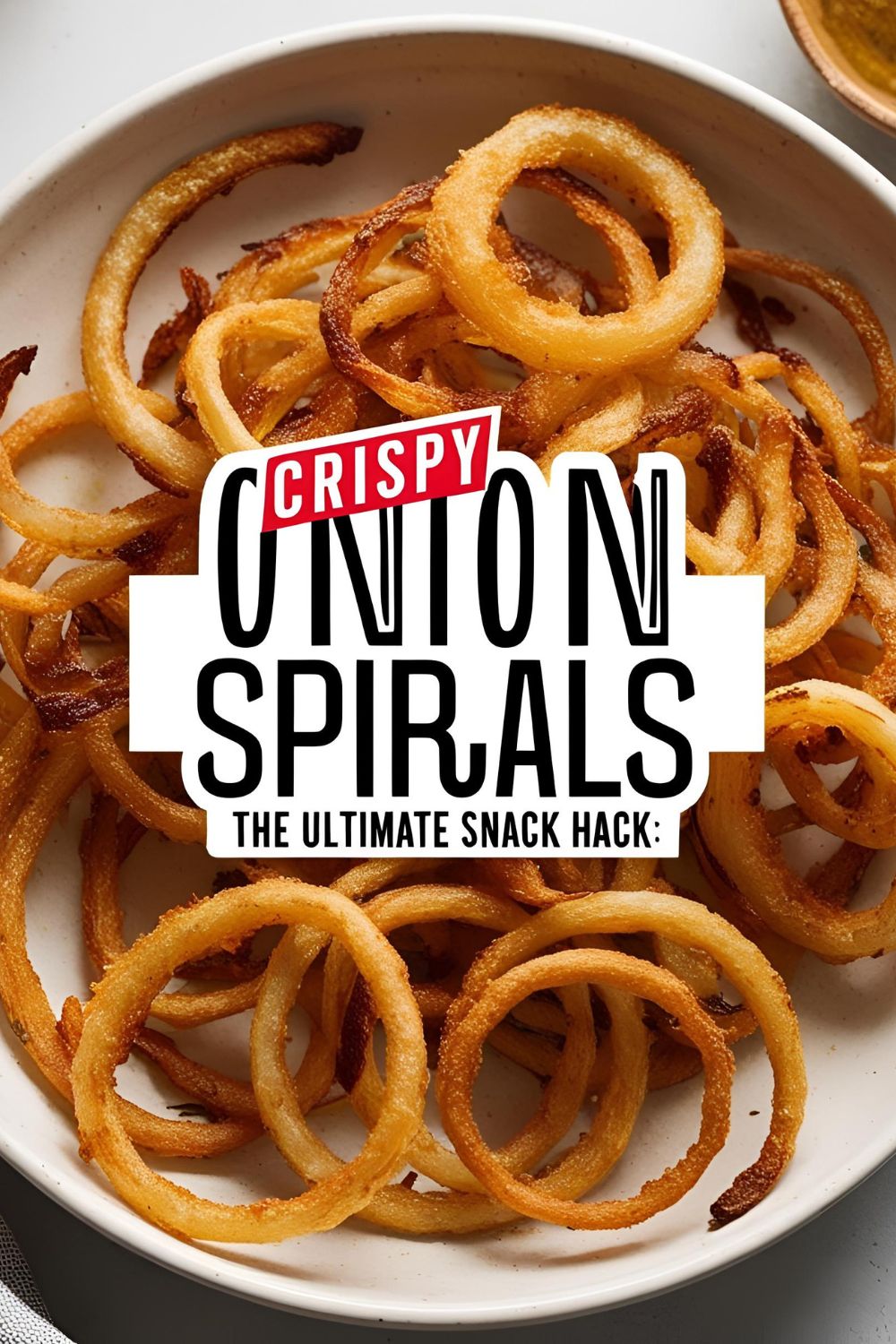 A plate of golden-brown onion spirals served with a dipping sauce