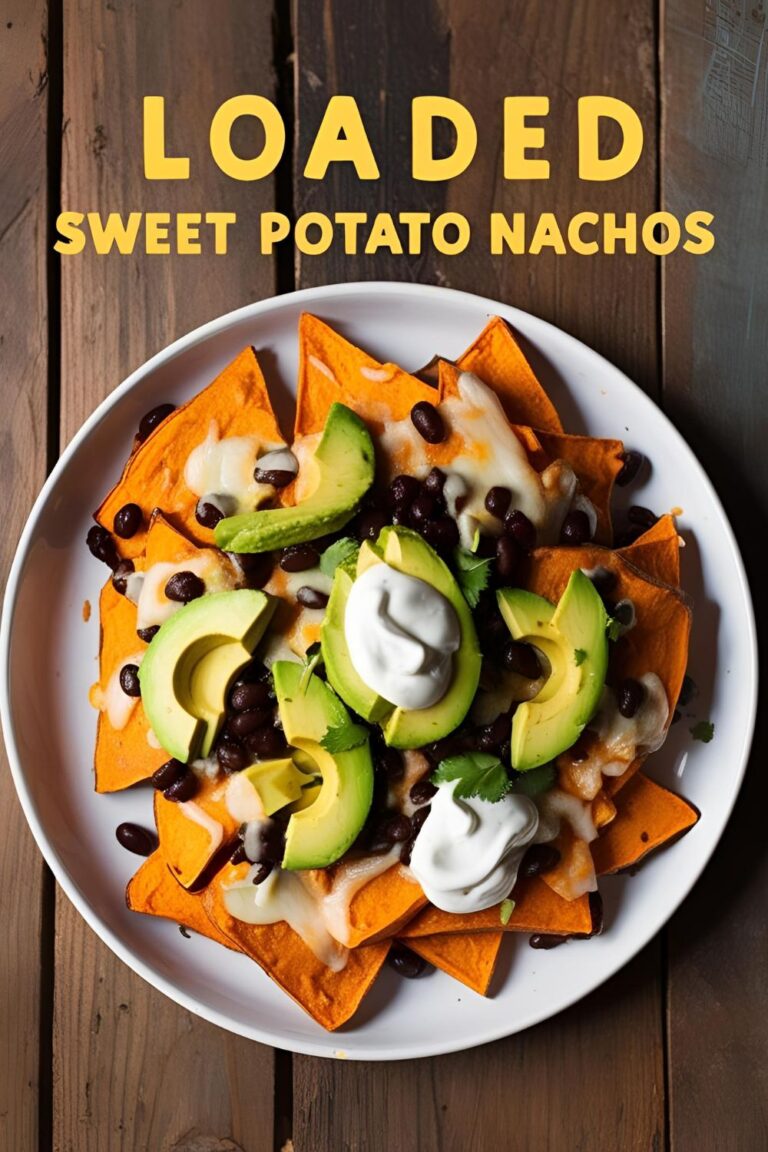 A tray of loaded sweet potato nachos topped with cheese, black beans, avocado, and sour cream.