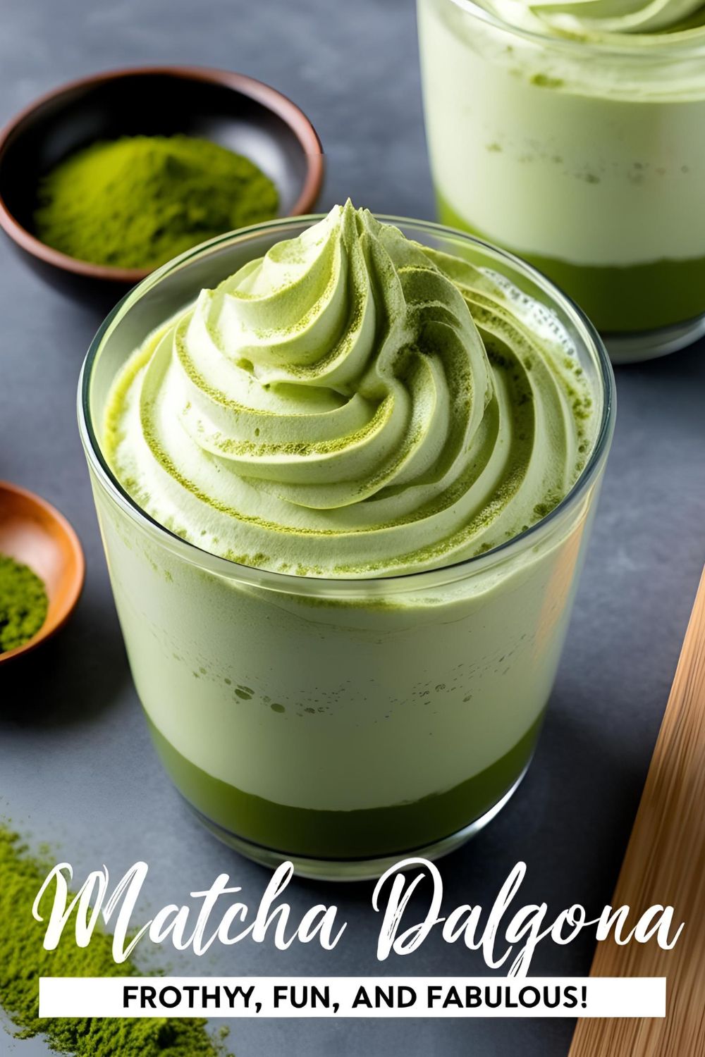 A glass of Whipped Matcha Dalgona with vibrant green foam atop creamy milk, garnished with a sprinkle of matcha powder.