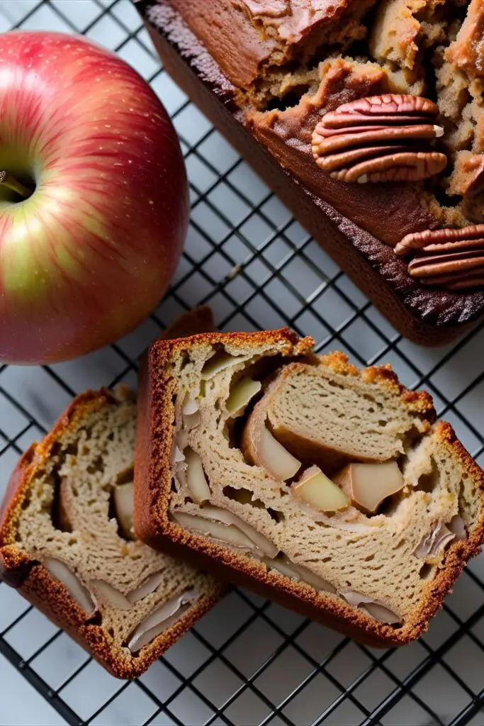 Close-up of moist apple cinnamon bread slice with visible apple chunks and cinnamon swirl.