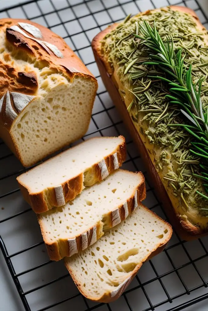 Bread loaf with crust and soft interior on cooling rack.