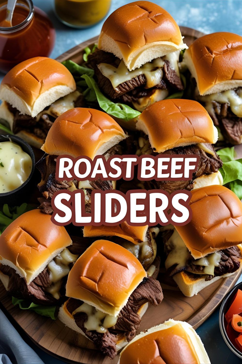 Row of melty roast beef sliders on a wooden board with dipping sauce