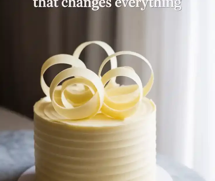 A Pinterest pin with the text "The White Chocolate Cake That Changes Everything" over a photo of an elegant, finished white chocolate cake.
