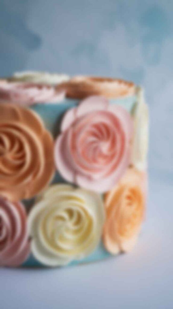 A close-up of a cake showing the artistic, textured effect of palette knife-painted buttercream flowers."