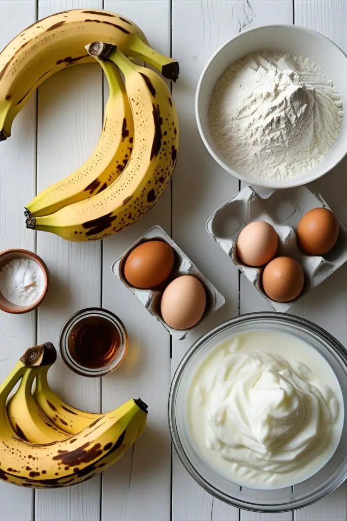 A flat-lay of healthy, natural ingredients for a first birthday cake, including ripe bananas, flour, eggs, and Greek yogurt.