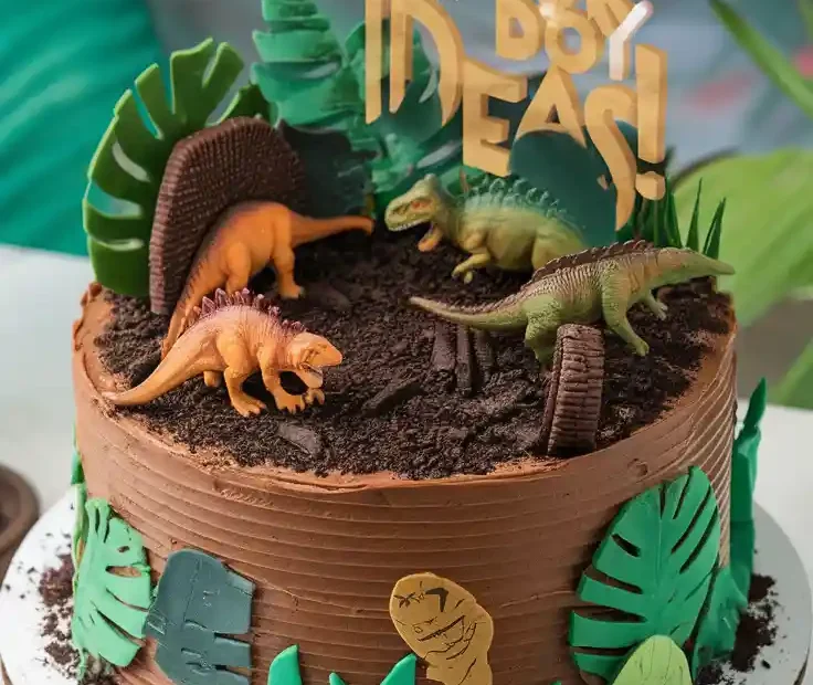 The COOLEST Cake for Boy Ideas!". Alt Text: A fun dinosaur-themed birthday cake with the text overlay "The COOLEST Cake for Boy Ideas!".