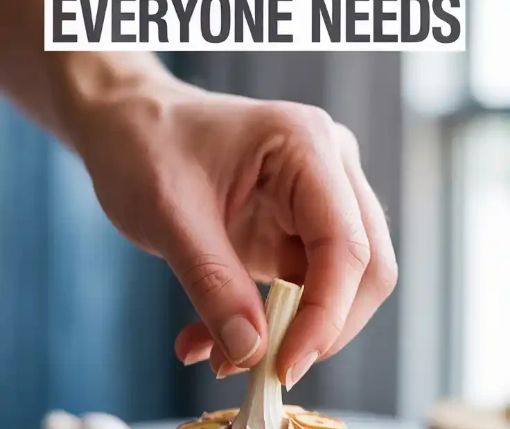 A Pinterest pin with the text "The 20-Minute Roasted Garlic Hack Everyone Needs" over a photo of someone squeezing a head of roasted garlic.