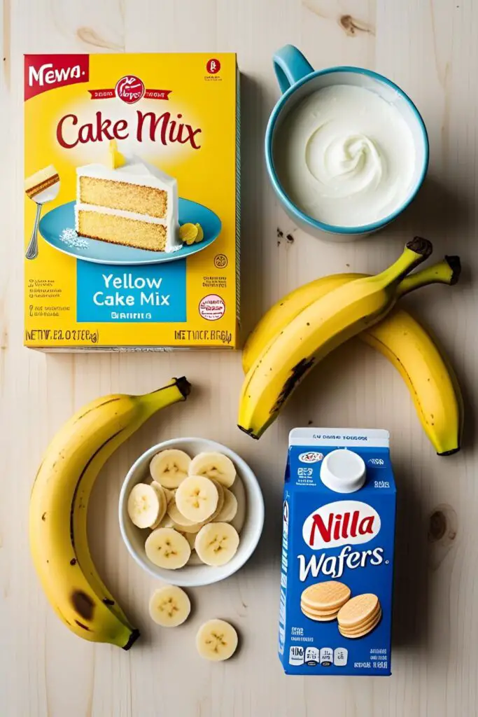 A flat lay of the key ingredients for a banana pudding cake: yellow cake mix, ripe bananas, Nilla wafers, and heavy cream.

