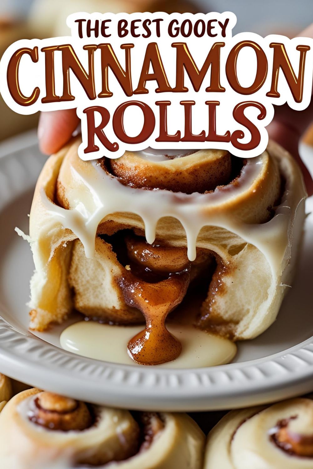 A gooey cinnamon roll being pulled apart with the text overlay "The Best Gooey Cinnamon Rolls."