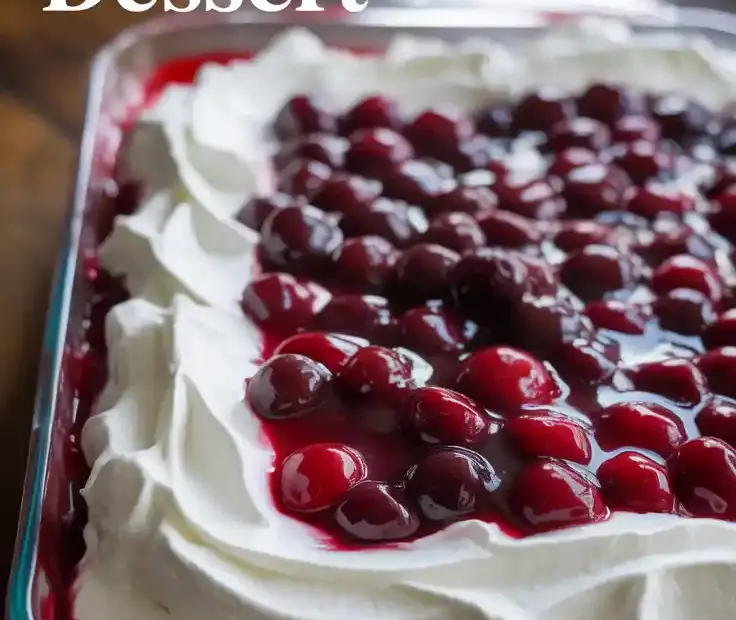 Text overlay "The Easiest Cherry Delight Dessert" over a stunning, top-down image of a whole 9x13 pan of the finished cherry delight dessert, showing vibrant red cherries and fluffy white topping.