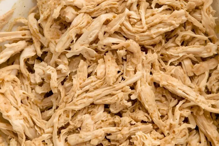 Fluffy crockpot shredded chicken in a bowl with the text "Crockpot Shredded Chicken."