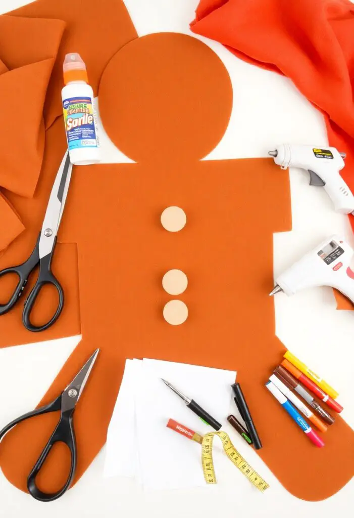 A flat lay of craft supplies needed to make a gingerbread man costume: brown felt, white felt, glue, and scissors.