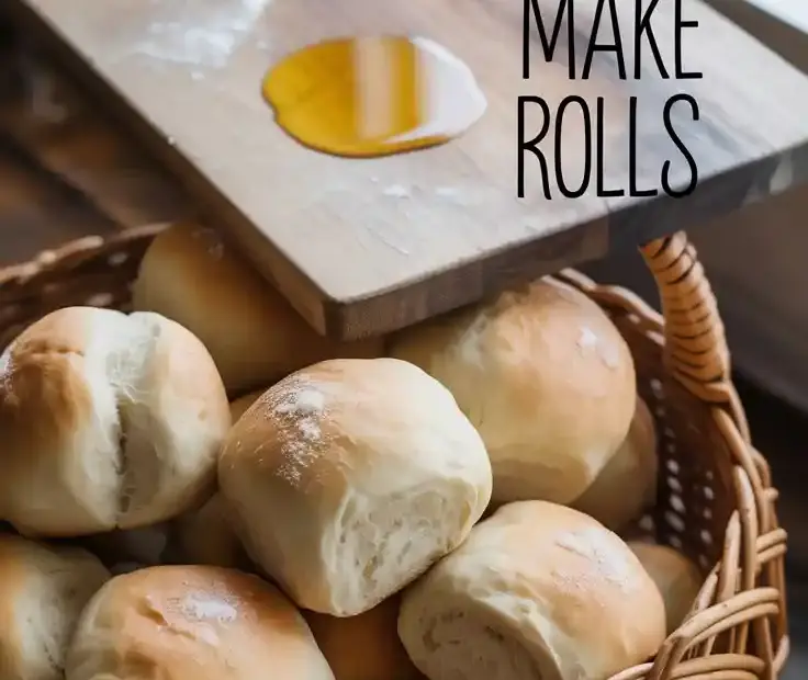 A basket overflowing with golden brown, soft homemade rolls, with a pat of butter on a wooden board in the background.