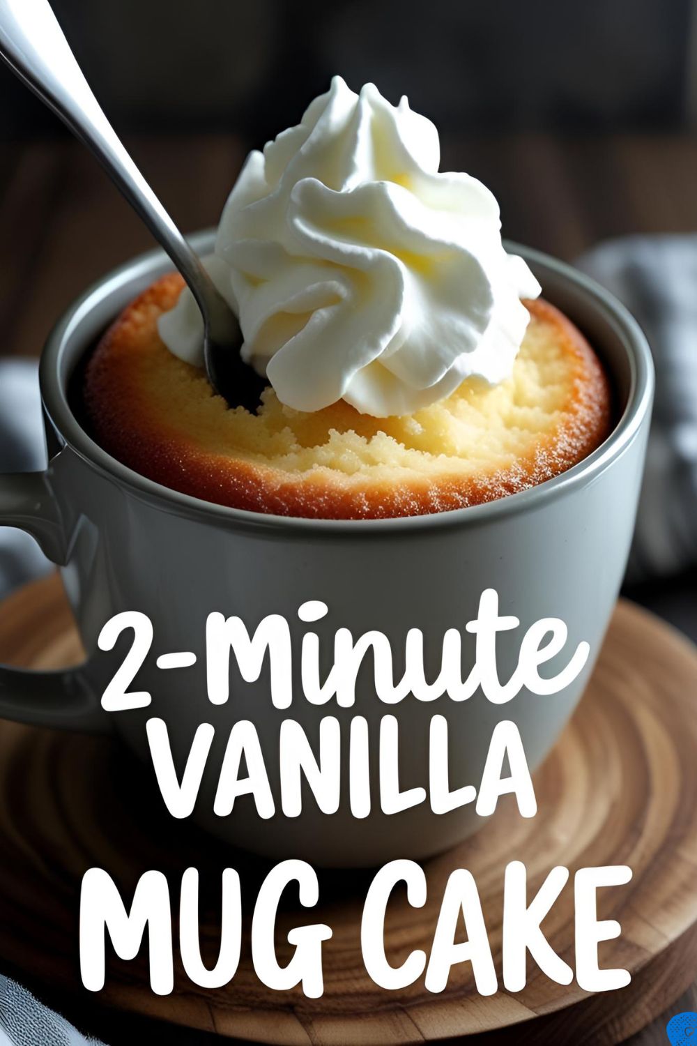 A delicious and fluffy vanilla mug cake in a white mug, topped with whipped cream and sprinkles.