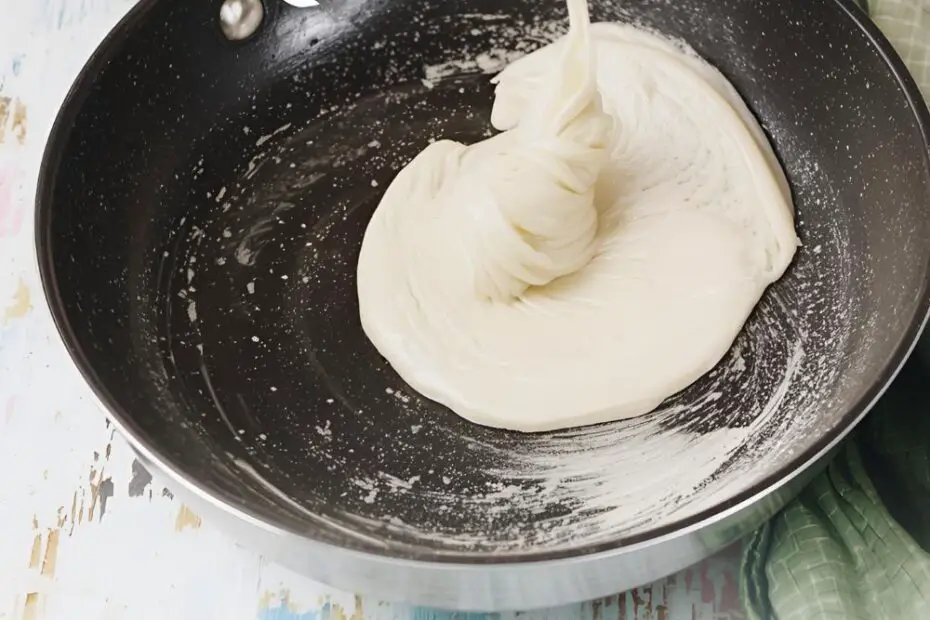 Text overlay "How to Make Crepes Easy" over a beautiful shot of a thin, delicate crepe being folded in a pan with strawberries and Nutella.