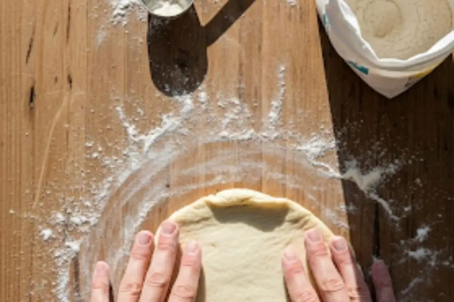 Text overlay "How to Make Pastry Dough" over a beautiful image of hands gently pressing a disc of homemade pastry dough, with a light dusting of flour, on a wooden surface.