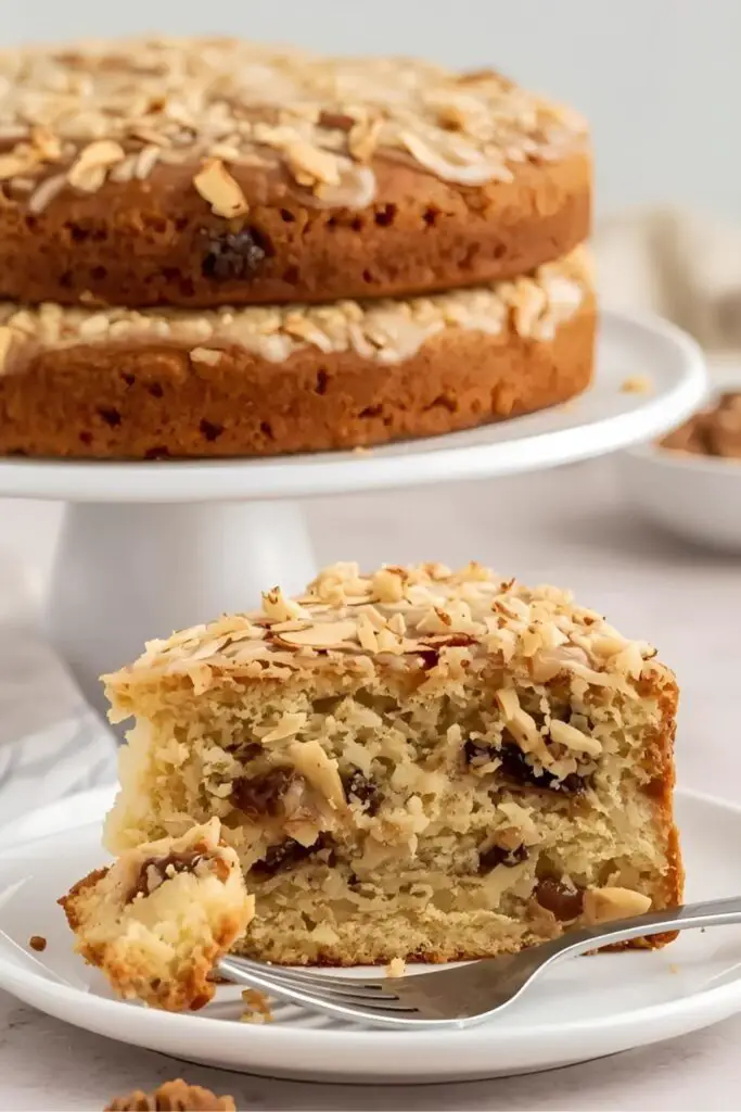 Generate two distinct images side-by-side. Image 1 (Stacked Layers): A fully assembled two-layer lumberjack cake on a cake stand, with the golden-brown, bubbly coconut-almond topping clearly visible. Image 2 (Close-Up Slice): A close-up shot of a slice of lumberjack cake on a plate, showcasing the moist texture of the cake, the visible dates and coconut throughout, and the delicious broiled topping. A fork is resting beside the slice."