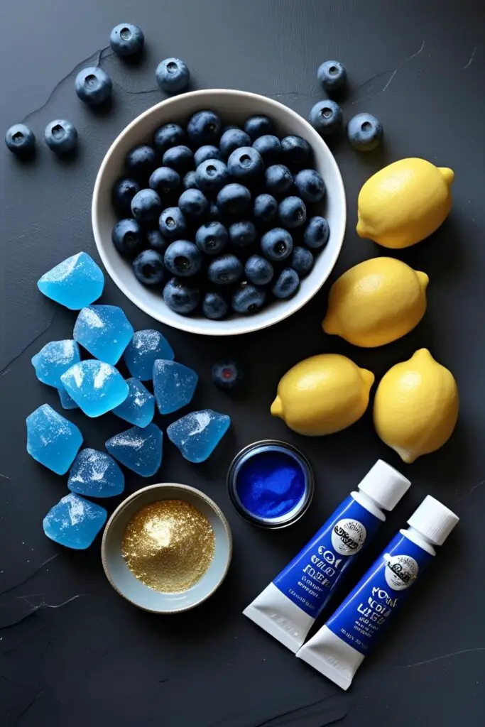 A flat lay of ingredients for a royal blue geode cake, including blueberries, lemons, rock candy, and gold dust.