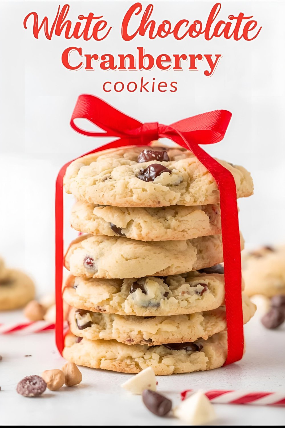 Text overlay "white chocolate cranberry cookies" on a background image of beautifully baked cookies on a cooling rack, with festive holiday decor.